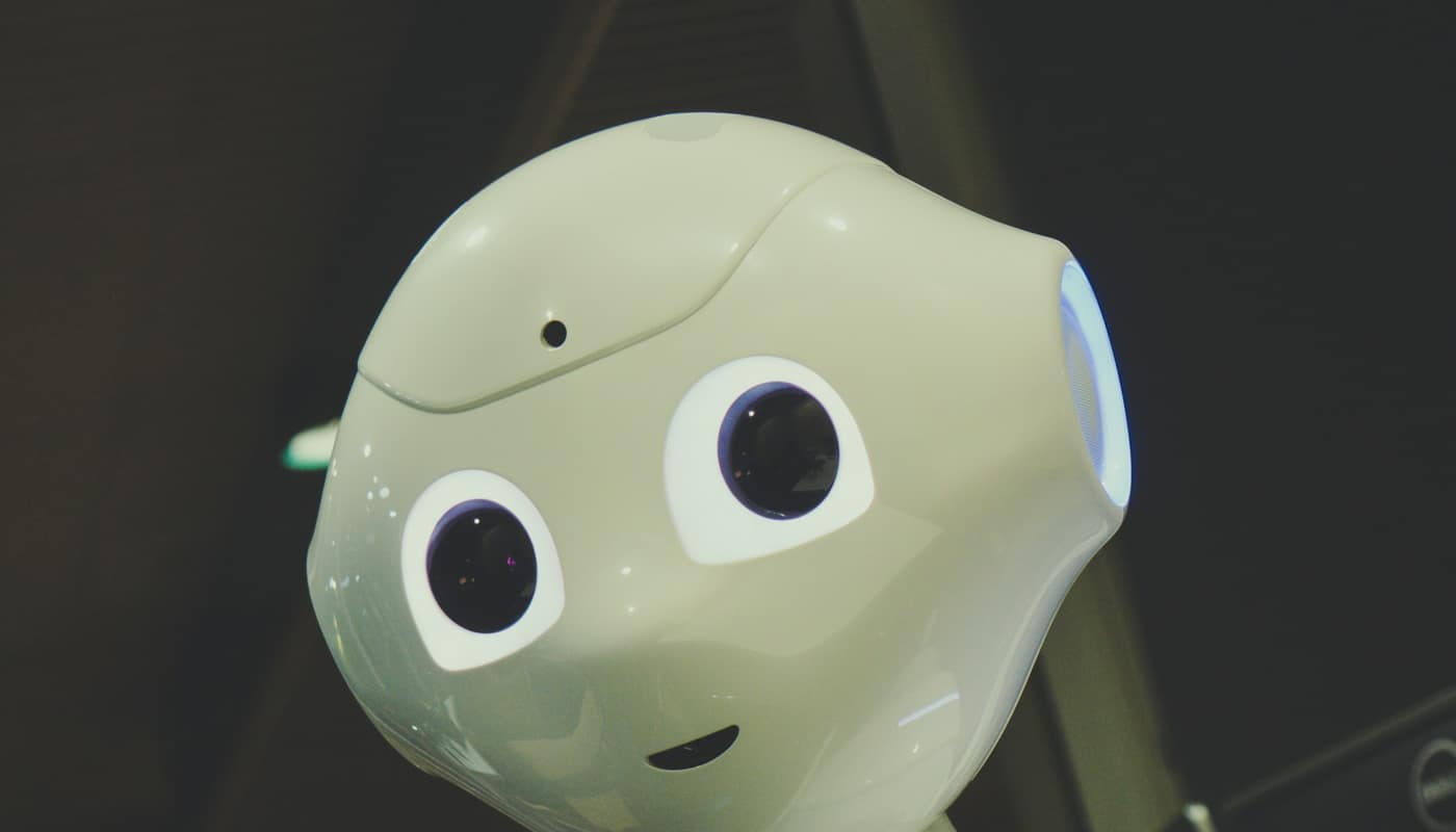 A small humanoid robot with a pale green head and large round eyes