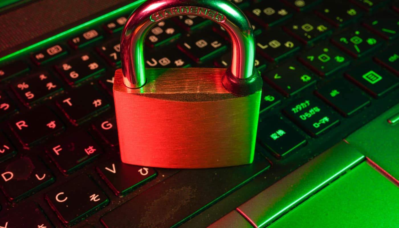 A red padlock on a backlit green keyboard