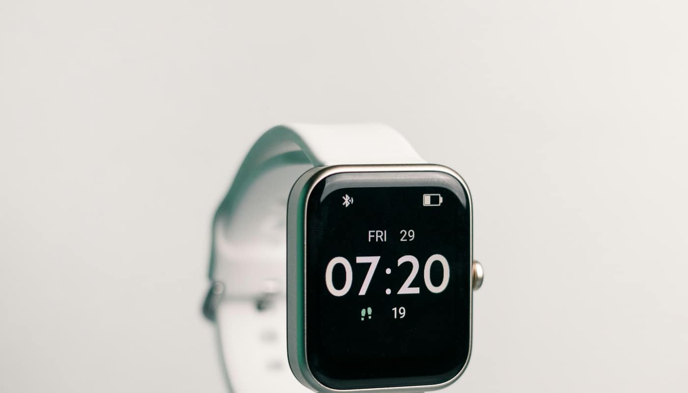 A smartwatch showing the time on a white strap